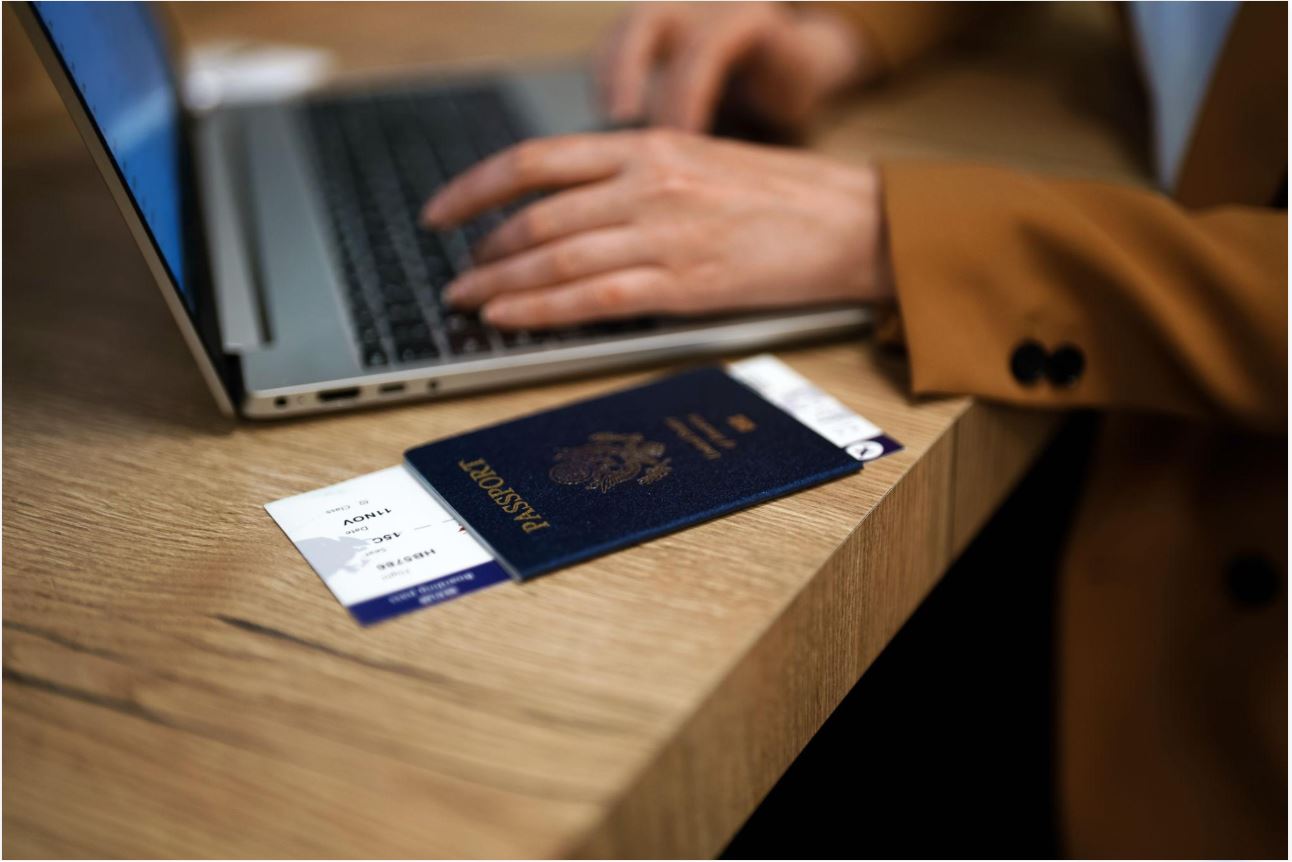 Passport, boarding pass and laptop for travel document preparation
